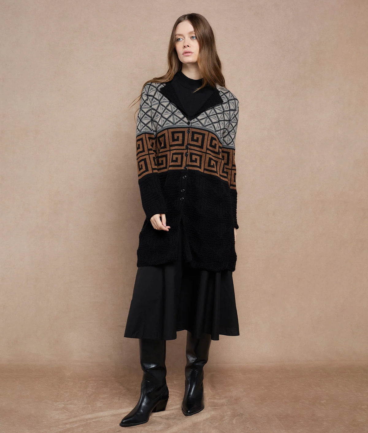Woman wearing a long black cardigan with a gray and brown geometric pattern.