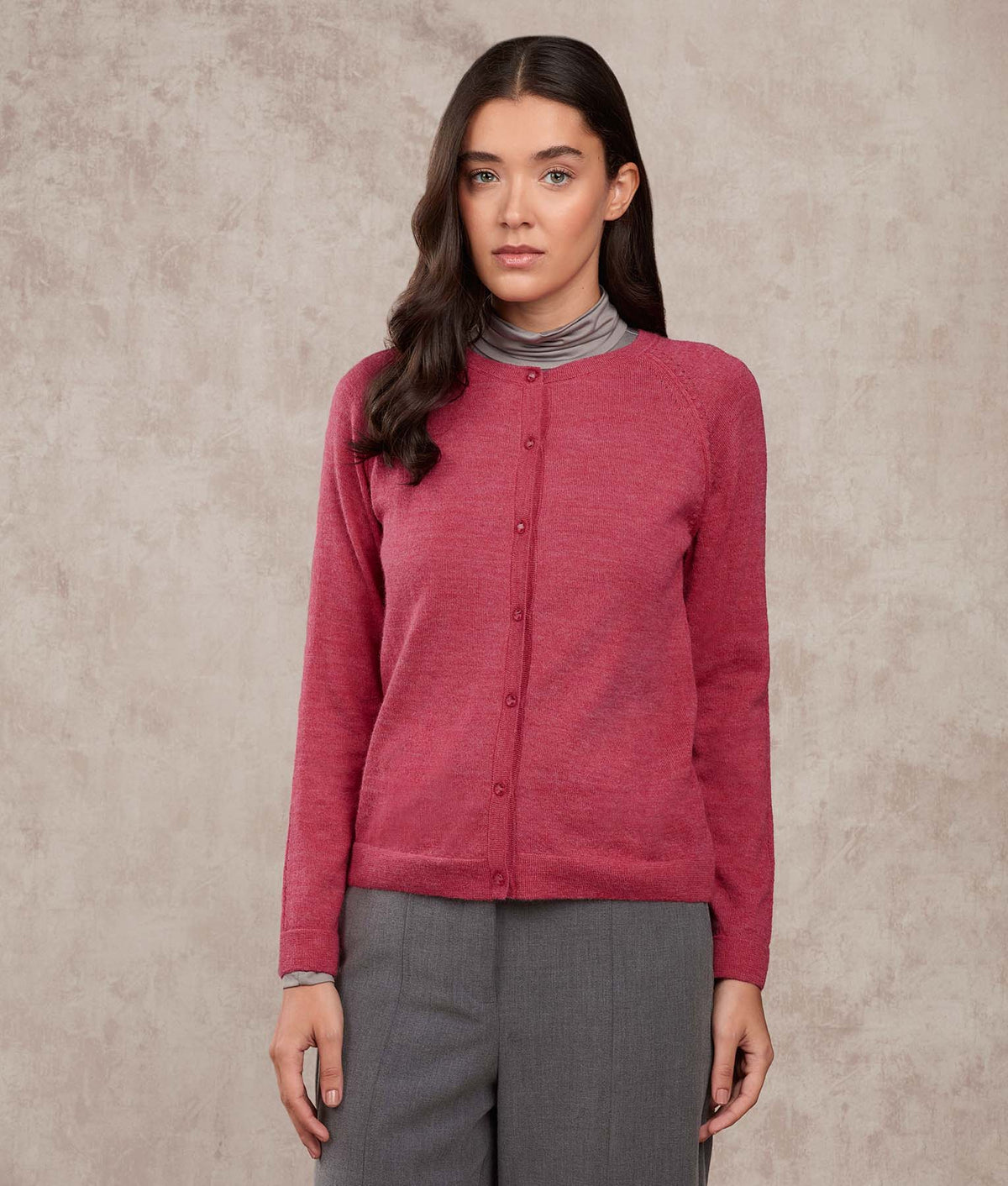 Woman wearing a heathered dusty rose button-up cardigan.