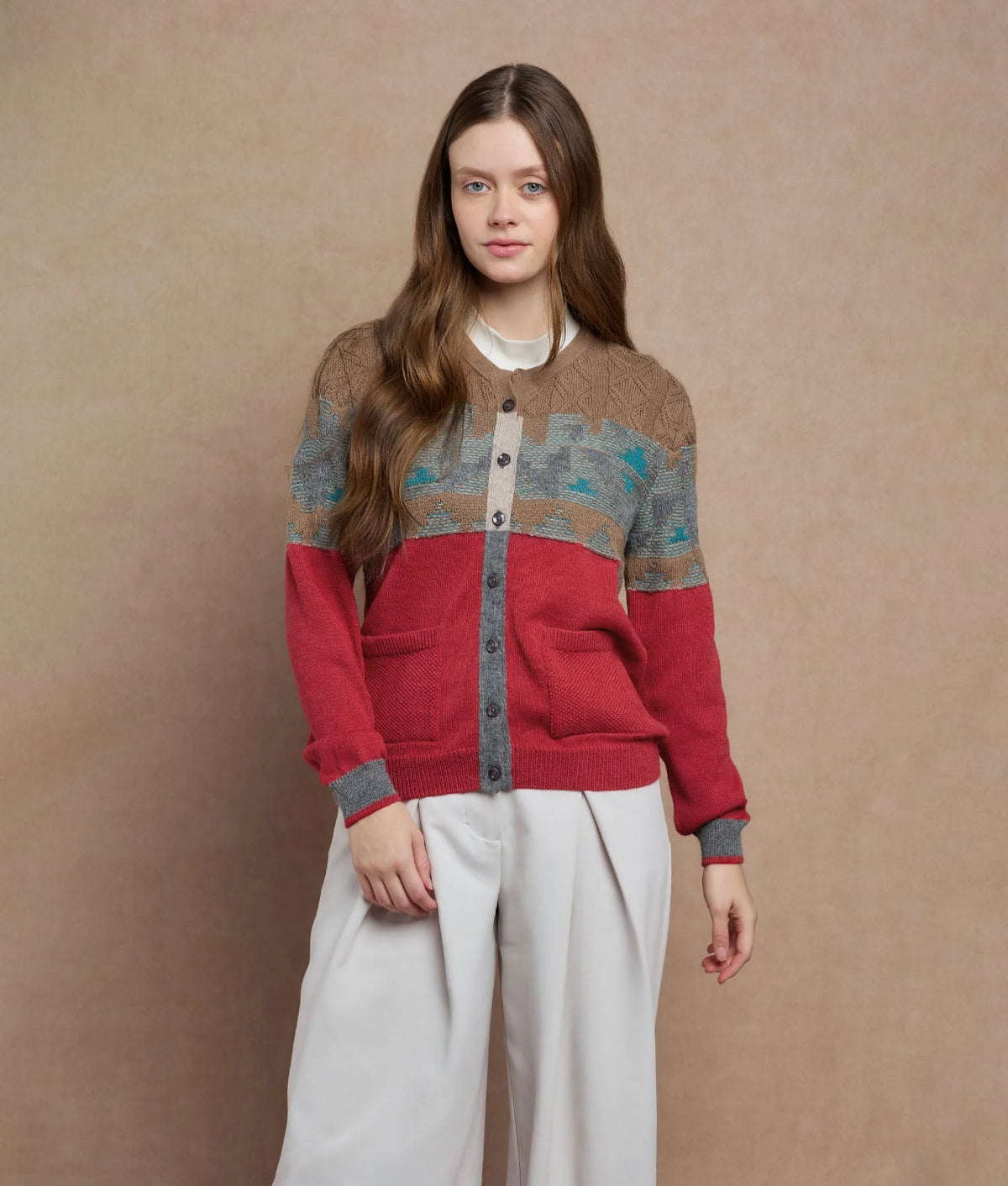 Woman wearing a color-block knit cardigan with brown, teal and red panels.