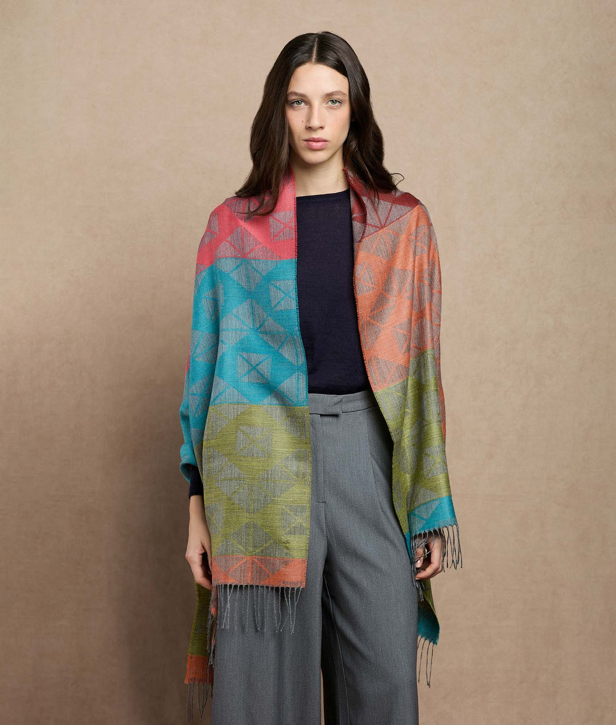 Woman wearing a large multicolor patterned shawl.