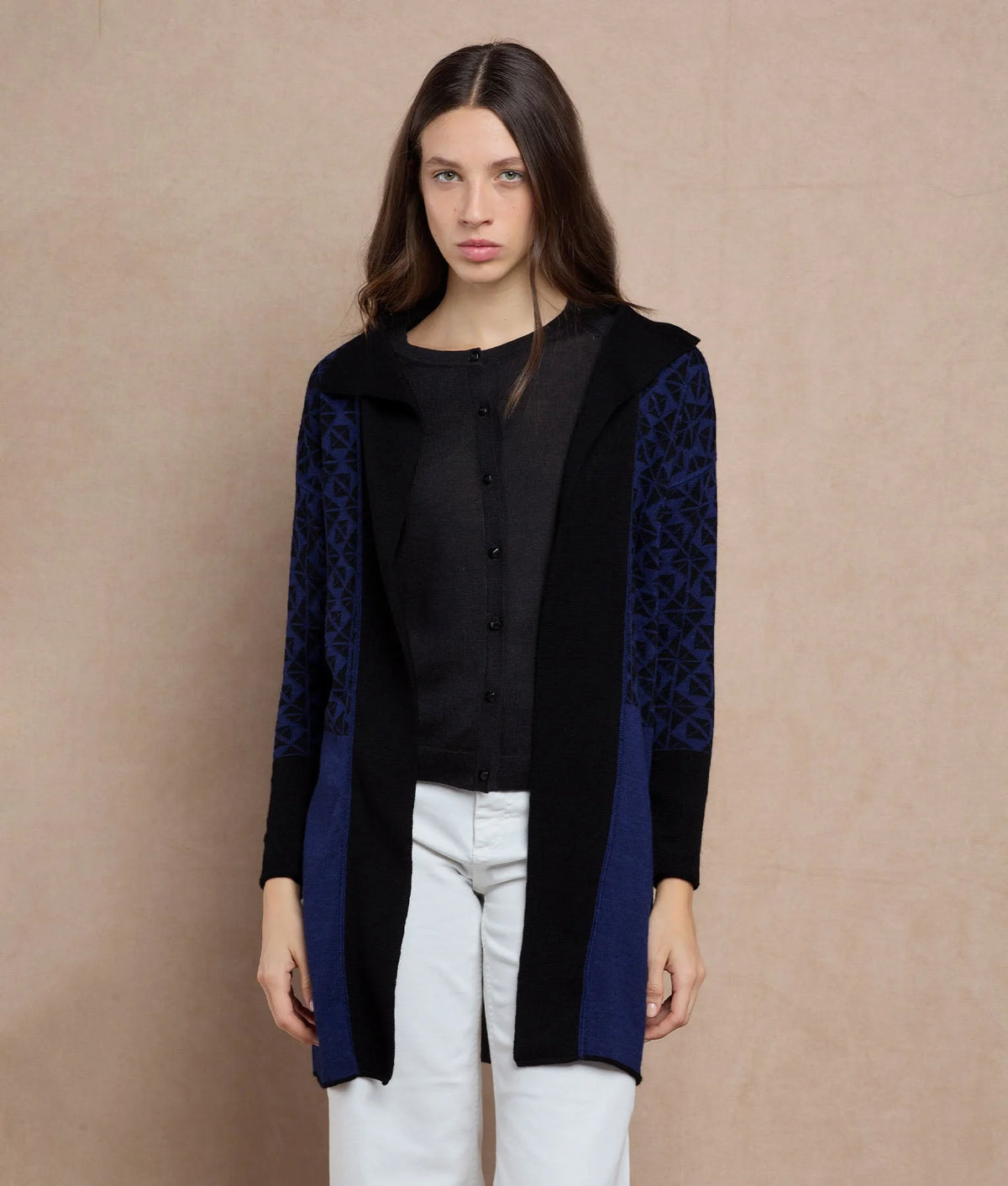 Woman wearing a black and navy blue cardigan with patterned sleeves.