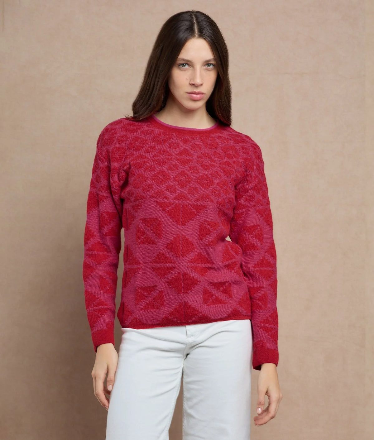 Woman wearing a red knit sweater with a tonal geometric pattern.