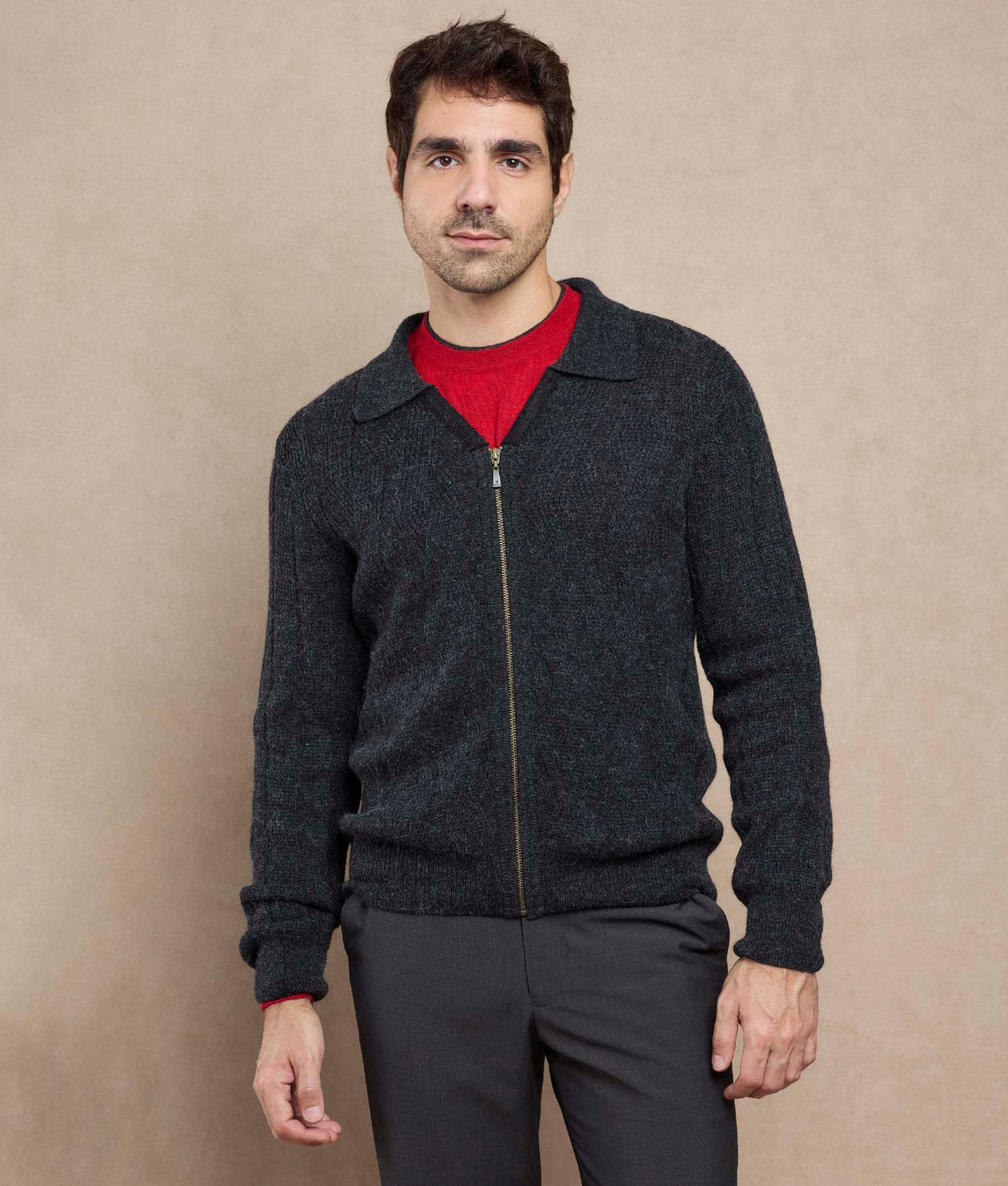 Man wearing a dark charcoal zip-up knit sweater.