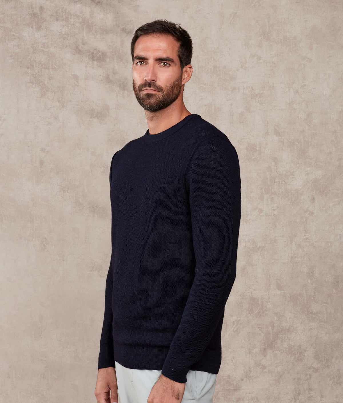 Man wearing a dark navy blue crewneck sweater.