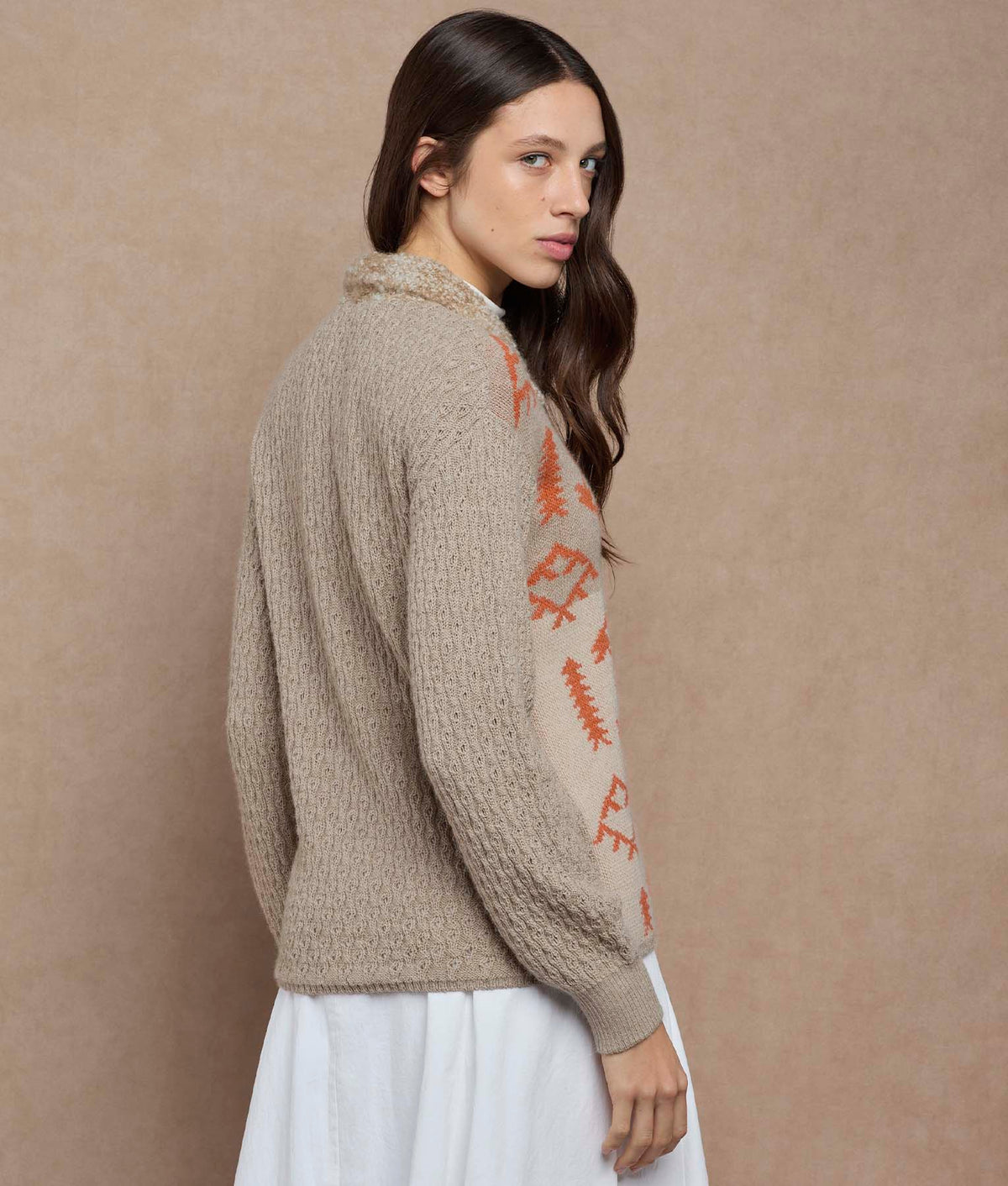 Side-back view of a beige knit cardigan with orange geometric patterns.