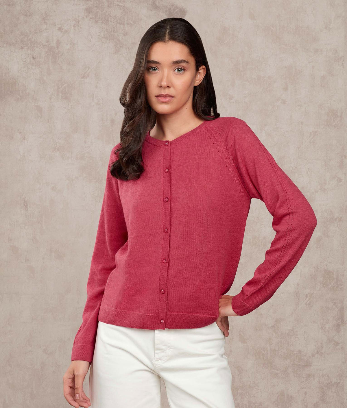 Woman wearing a dusty rose pink button-up cardigan.