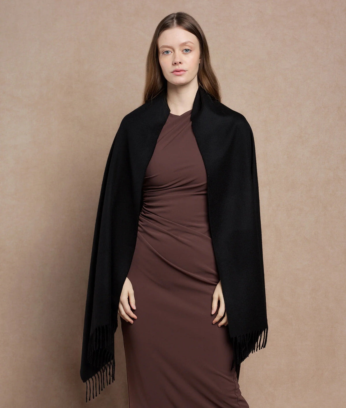 Woman wearing a black shawl over a brown dress.