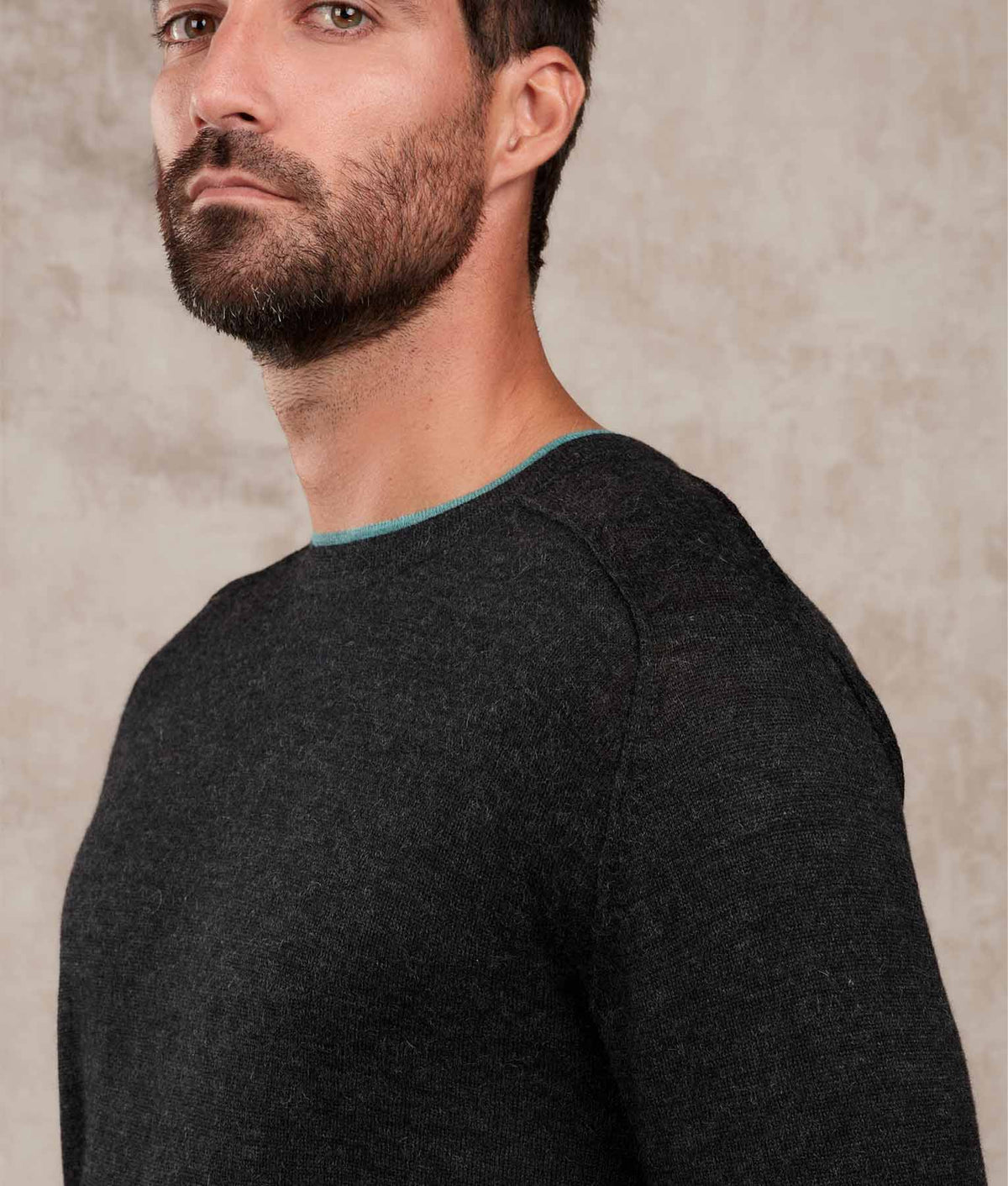 Close-up of a dark charcoal gray knit sweater with a contrasting light blue collar.