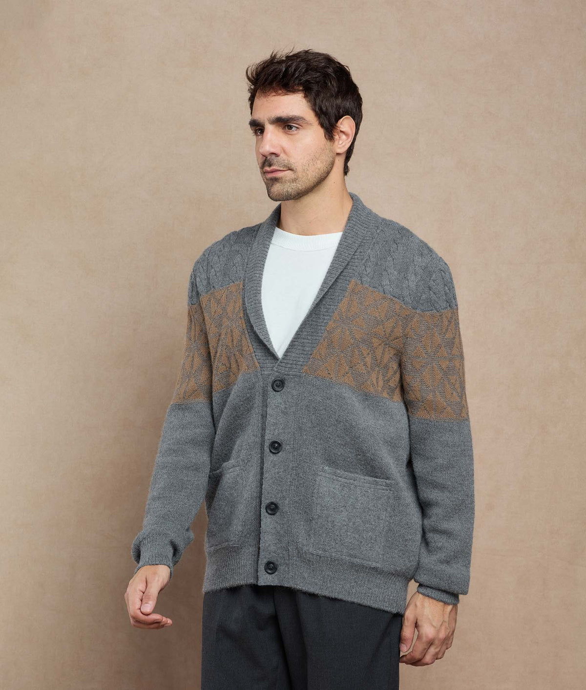 Man wearing a gray knit cardigan with brown patterned yoke panels.