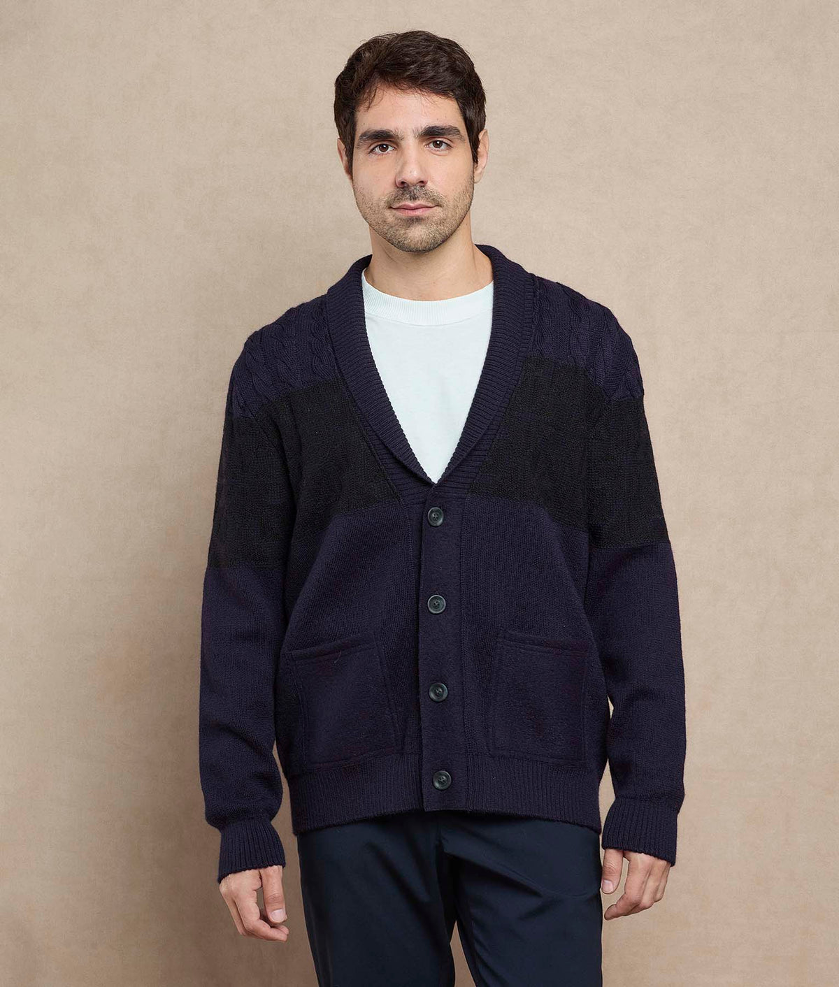 Man wearing a dark navy blue color-block knit cardigan.
