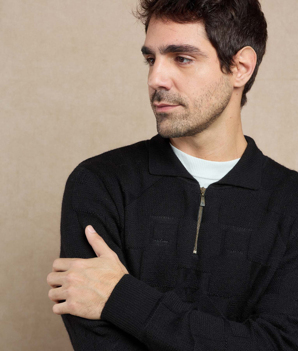 Man wearing a black textured zip-up sweater.