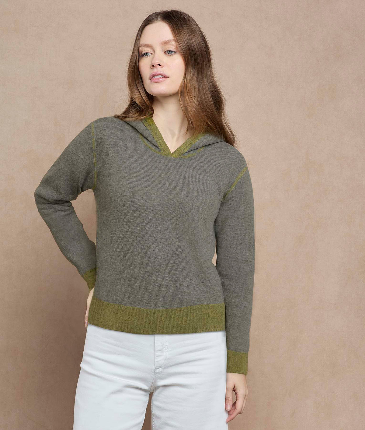 Woman wearing a gray sweater with green accents.