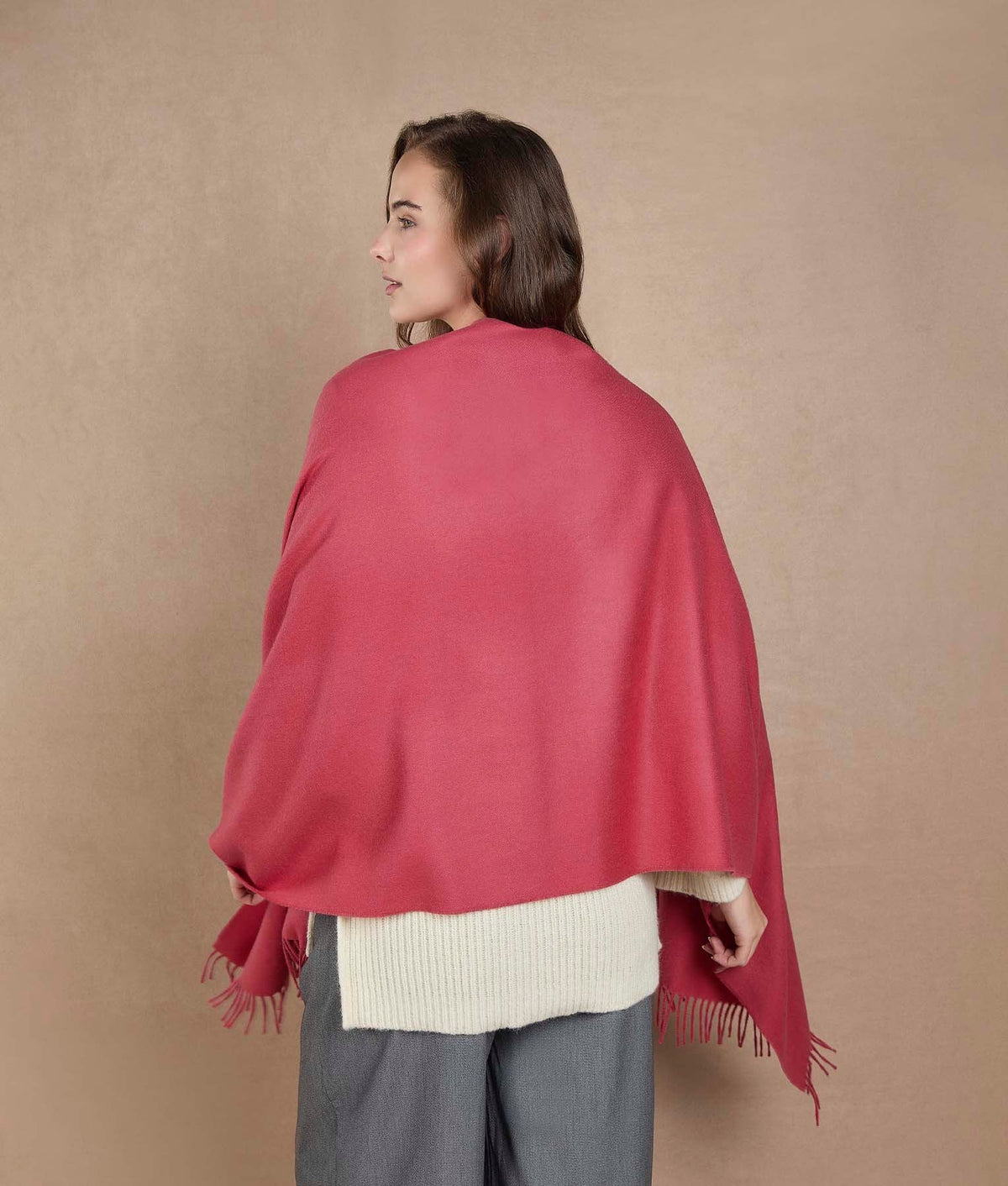 Back view of a woman wearing a vibrant pinkish-red shawl.