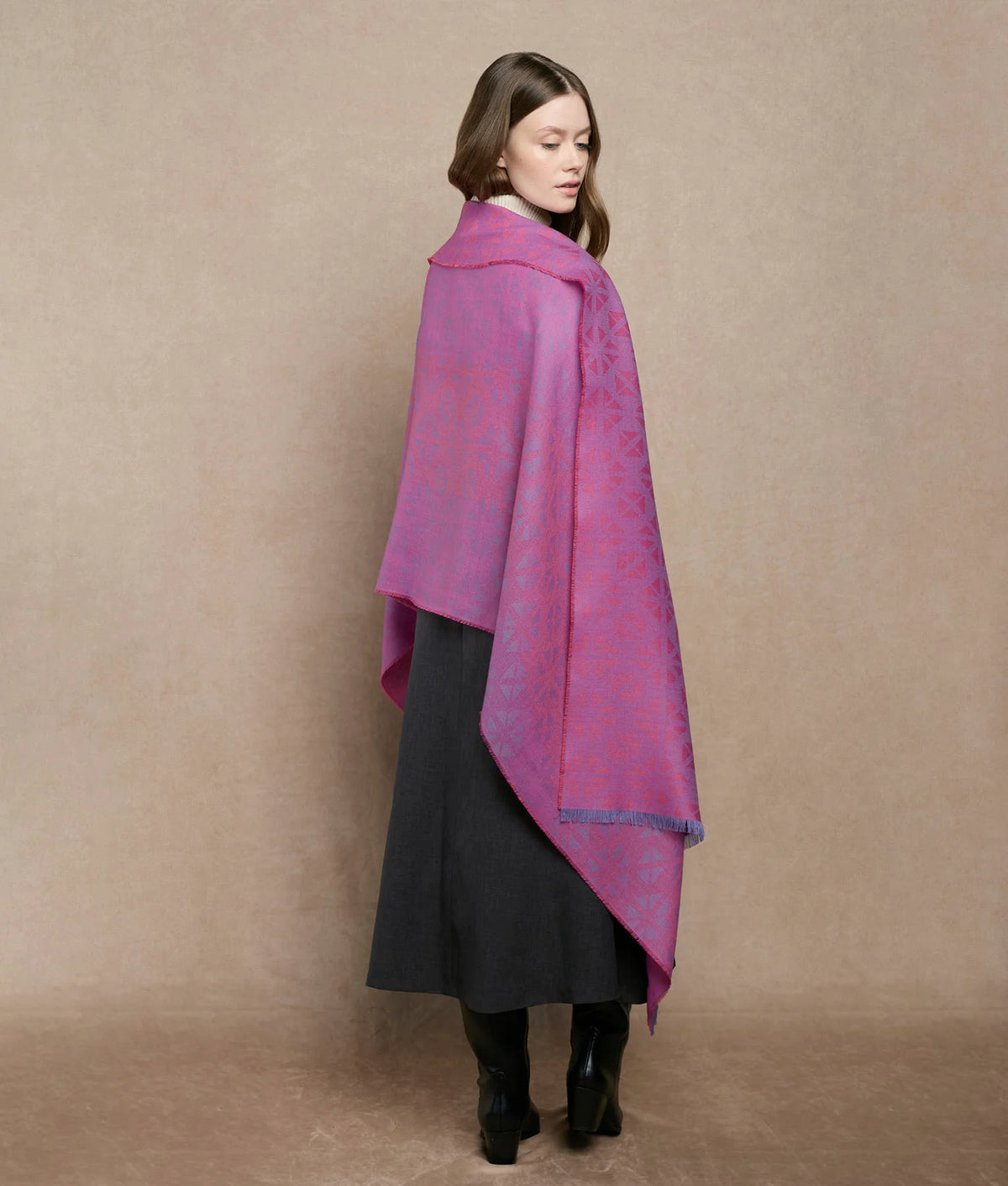 Woman wearing a draped magenta and purple patterned shawl.