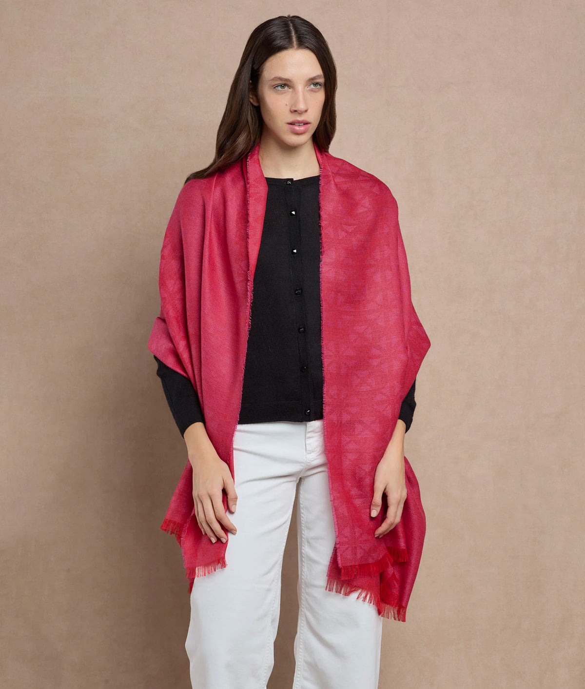 Woman wearing a vibrant magenta-red shawl with a subtle pattern and fringed edges.